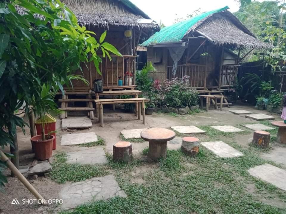 安蒂波洛Kambal Kubo Resthouse at Sitio Singalong Bgy San Jose Antipolo的花园,位于带凳子的房子前
