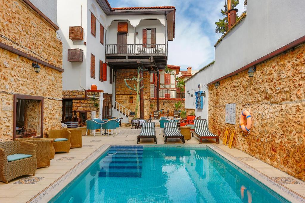 安塔利亚阿特尔亚艺术酒店的一座带椅子的庭院内的游泳池以及一座建筑