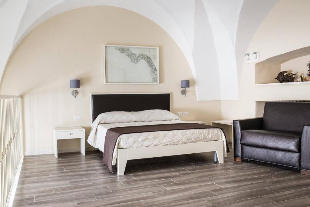 加利波利Faro Bianco Gallipoli Dependance的一间卧室配有一张床和一把椅子