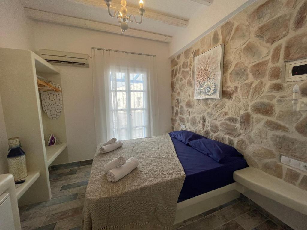 纳克索乔拉BURGOS BARRIO的一间卧室设有一张床和石墙