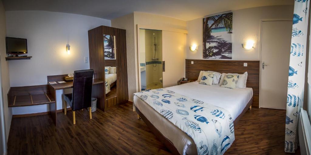 Saint-André-de-la-MarcheBrit Hotel Azur的酒店客房设有一张大床和一张书桌。