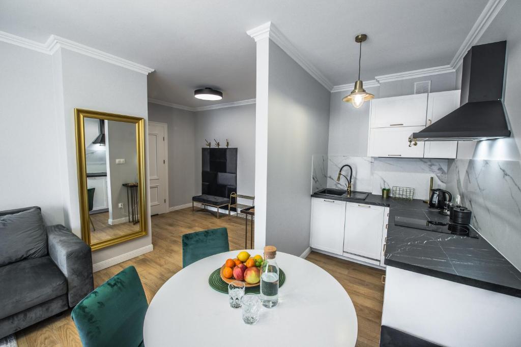 库多瓦-兹德鲁伊Słone Residence Apartamenty & Beer SPA的厨房以及带水果桌的客厅。