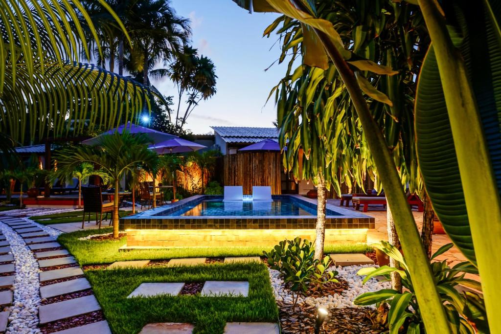 莫雷雷Pousada Boutique Coco Bambu Morere的棕榈树度假村内的游泳池