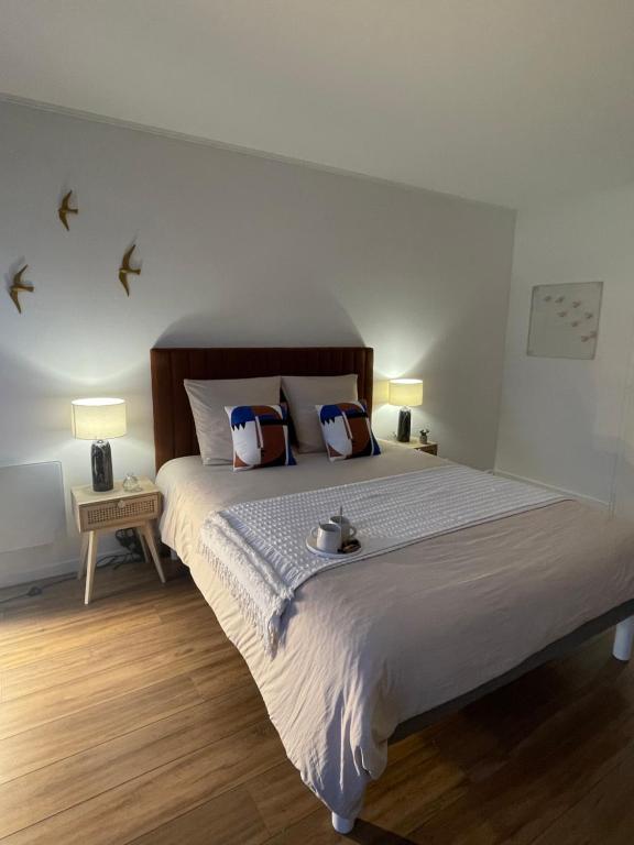 奥祖瓦尔-拉费里耶尔Appartement Entre Paris et Disney的卧室配有一张大床,墙上有鸟