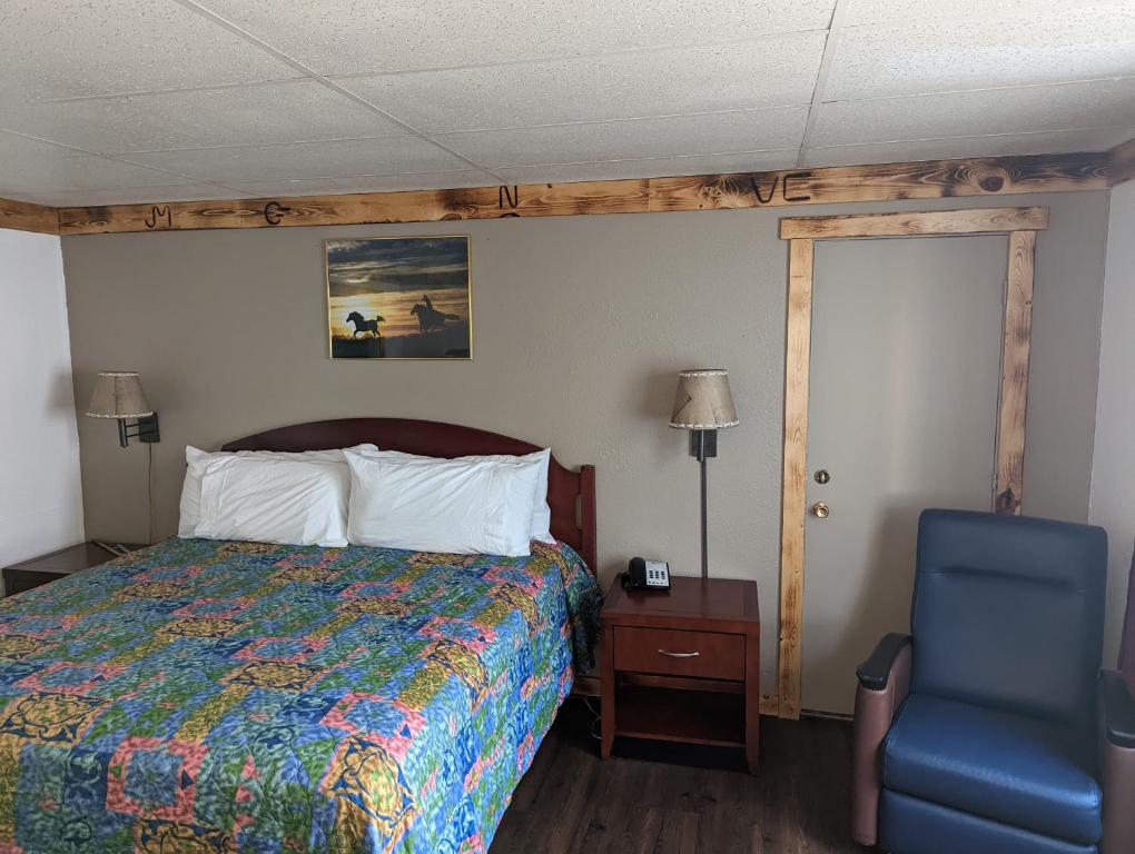 道奇城Wyatt Earp Hotel的一间卧室配有一张床和一张蓝色椅子