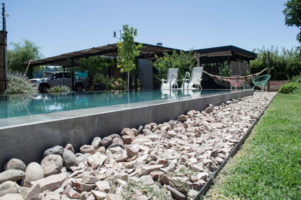 查克拉斯德科里亚Refugio Padma的游泳池周围设有椅子和岩石