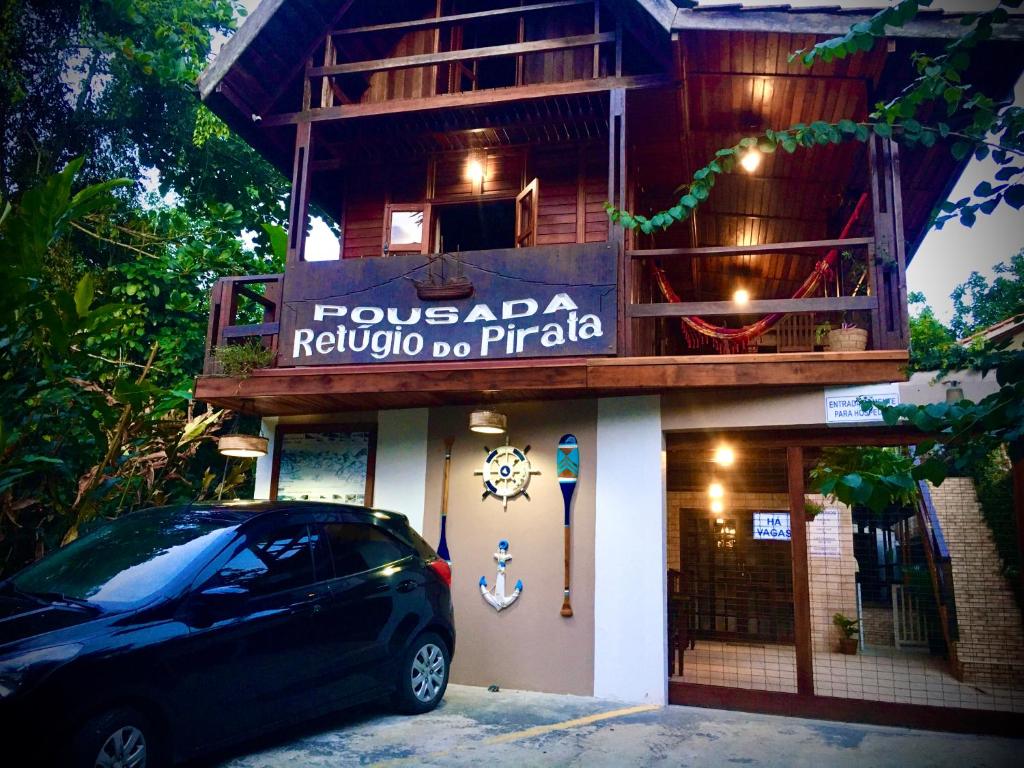 特林达德Pousada Refugio do Pirata的停在大楼前的一辆黑色汽车