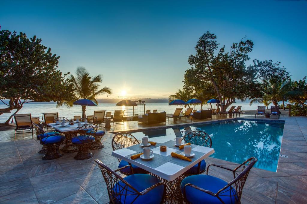 珀拉什奇亚Mariposa Belize Beach Resort的一个带游泳池和桌椅的度假酒店