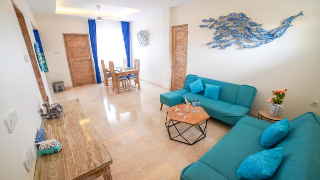 沙努尔Ocean Star Apartment Sanur的客厅配有蓝色的沙发和桌子