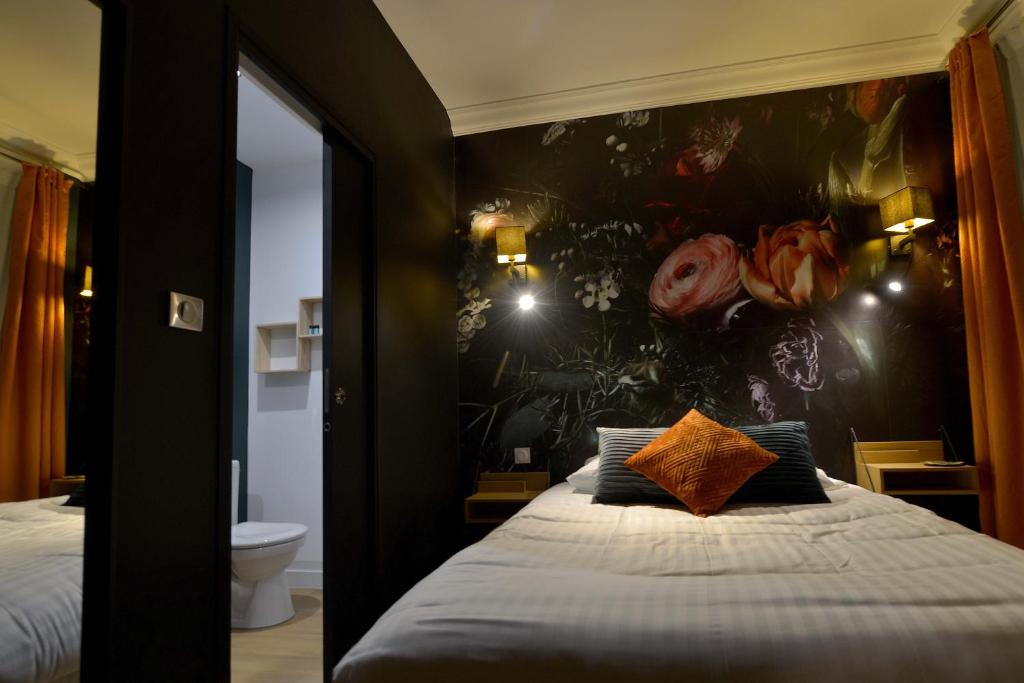 瑟堡Hôtel Le Tiburon的一间卧室配有一张带花墙的床