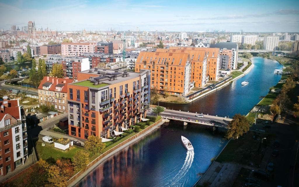 格但斯克Dwie Motławy Apartinfo Apartments的享有河流和建筑的城市空中景致