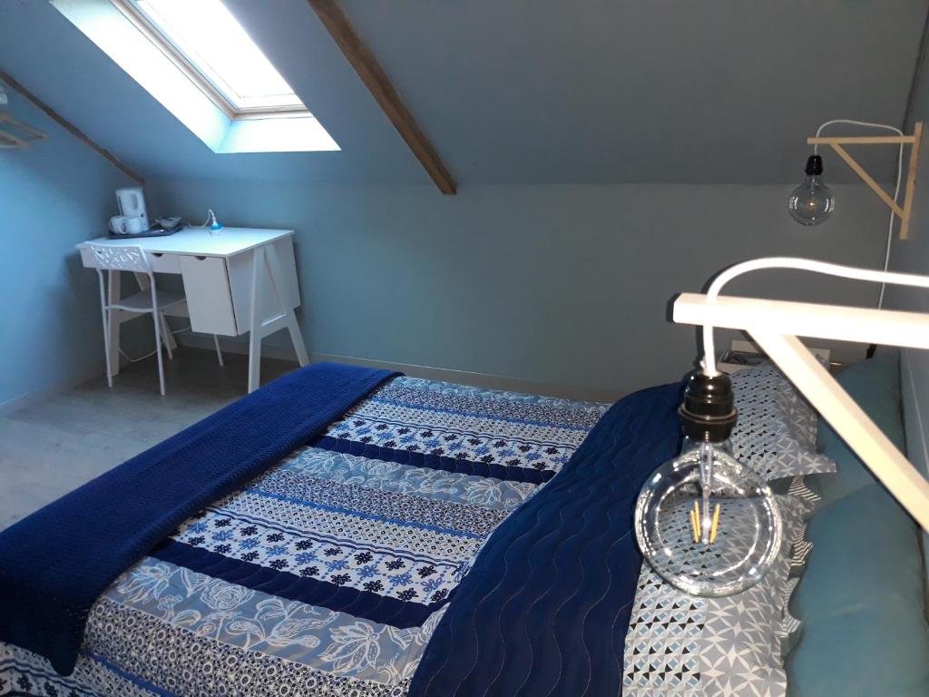 Saint-DenoualAu Ker Lauriers chambres et table d Hôtes的一间卧室配有一张带蓝色床单的床和一张桌子。