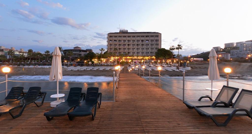 科纳克勒Anitas Hotel的海滩上带椅子和遮阳伞的木板路