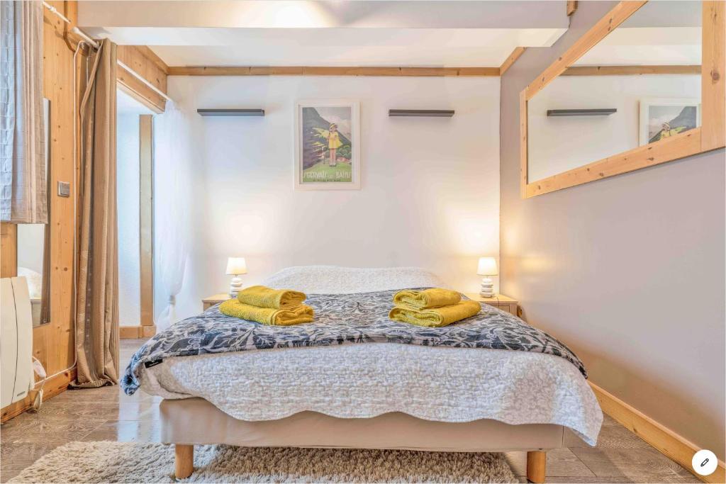 圣热尔韦莱班CHAMBRE INDÉPENDANTE avec SALLE DE BAIN INDÉPENDANTE au RDC d un chalet à 25 kms Chamonix的一间卧室配有一张床,上面有两条毛巾