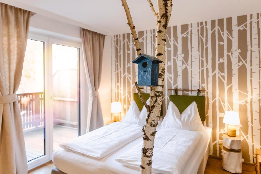 圣沃尔夫冈Das Franzl - Bett & Brot的一间卧室,卧室里设有一张树和鸟舍的床