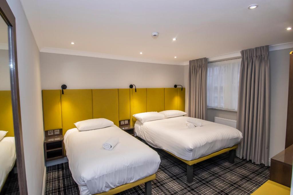 伦敦霍德华温切斯特酒店的酒店客房设有两张床和窗户。
