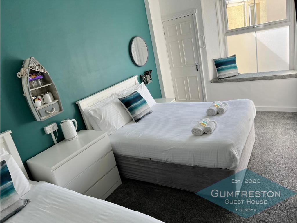 滕比Gumfreston Guest House的蓝色墙壁客房的两张床