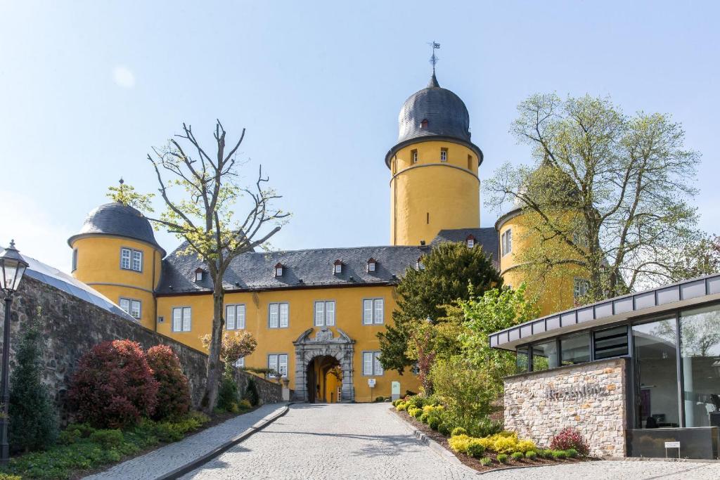 蒙塔鲍尔蒙塔鲍尔城堡酒店的一座大型黄色建筑,有两个塔楼