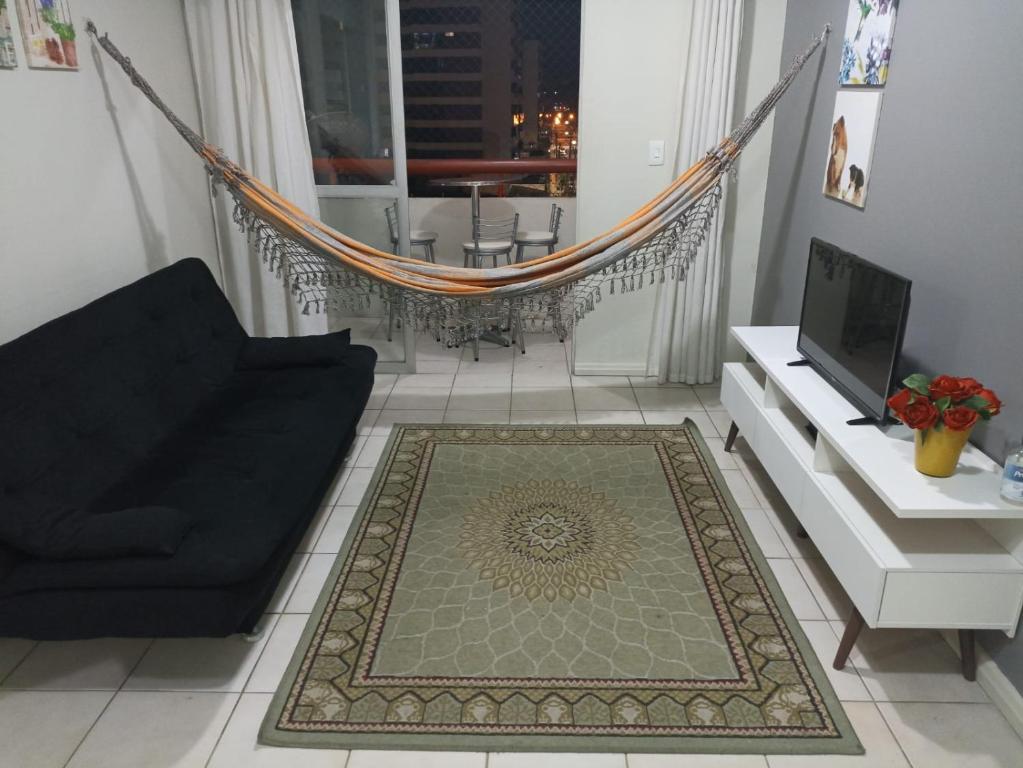 马塞约Braga Apartamento Temporada Maceió的客厅配有黑色沙发和吊床