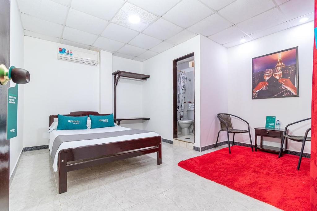 约帕尔Ayenda Vanguard的一间卧室配有一张床和红色地毯
