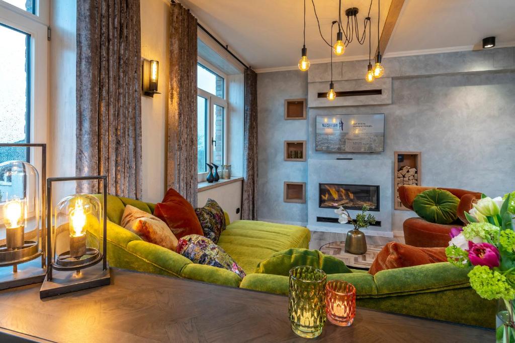 巴特塞格贝格Apartment Deluxe - a64667的客厅设有绿色沙发和壁炉