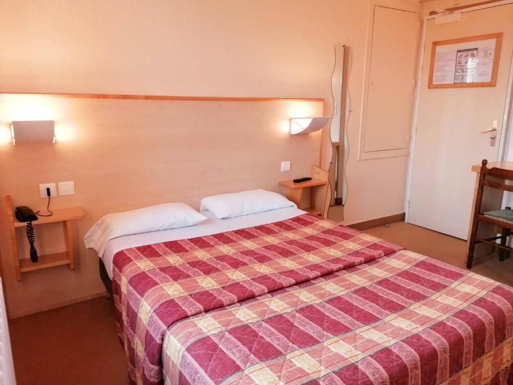 波利尼Les Charmilles的酒店客房,配有一张带铺着地毯的床