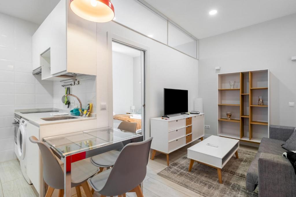 马德里Minty Stay - Hortaleza Studio的厨房以及带桌椅的起居室。