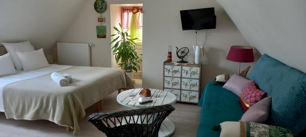 塞雷拉龙德Aux penates de Toni Beauval的一间卧室配有一张床、一张沙发和一张桌子