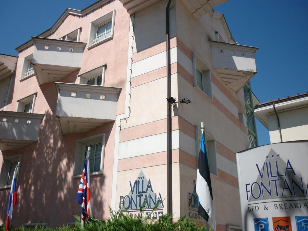 特伦托卡尼丰塔纳别墅酒店的前面有旗帜的建筑