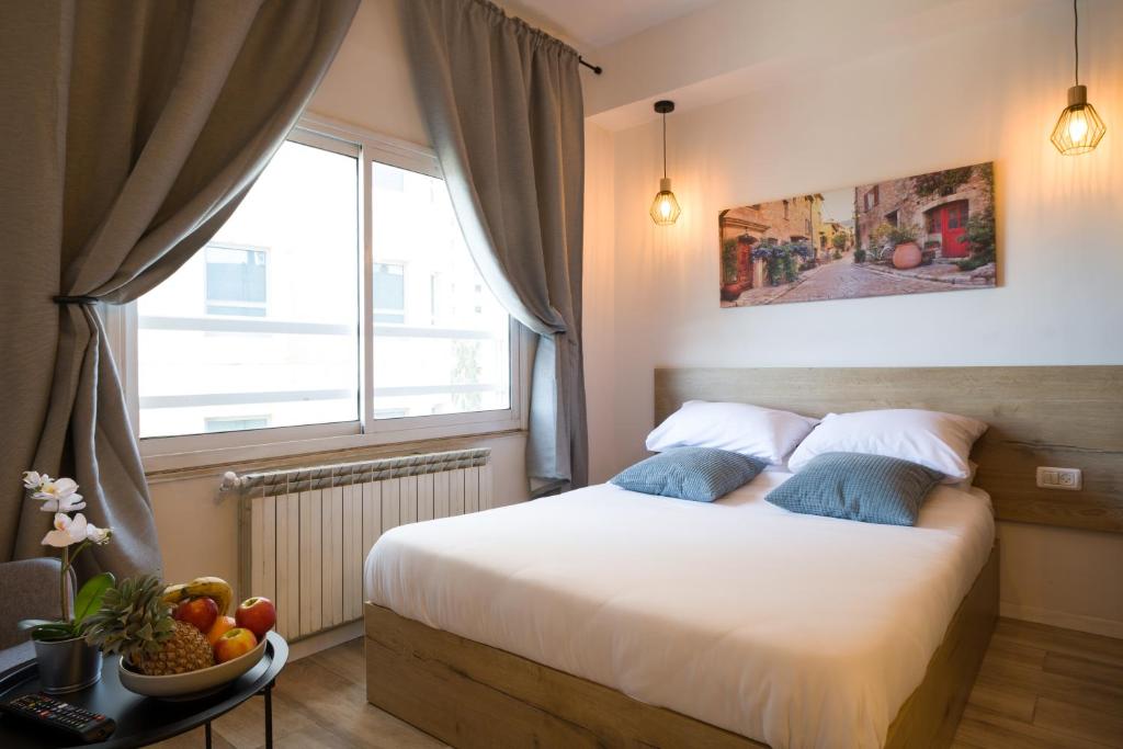 耶路撒冷Aju Hillel 14的一间卧室,配有一张带窗户的床和一碗水果