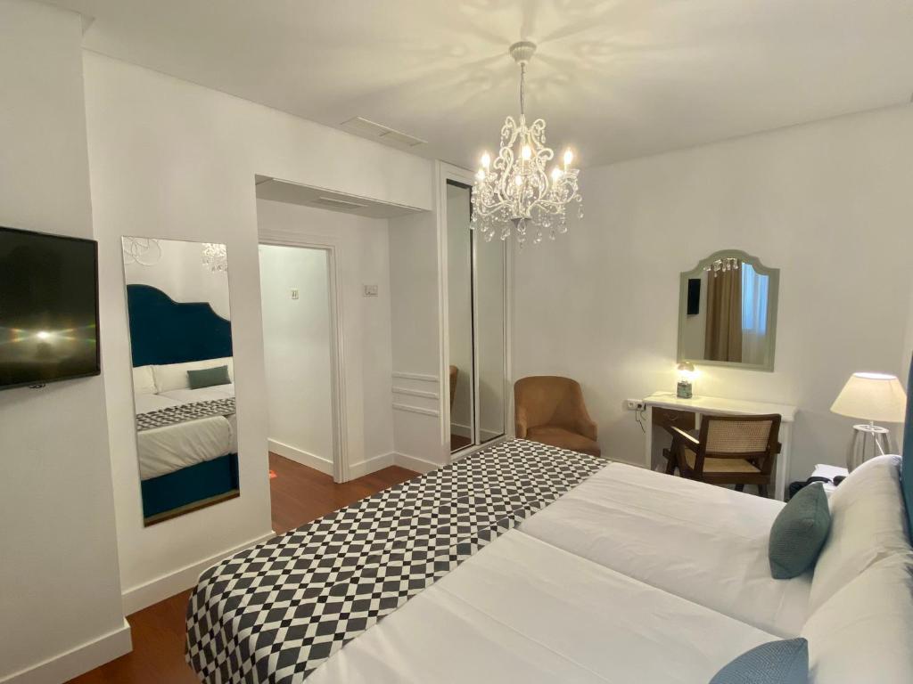 塞维利亚塞维利亚德比酒店的卧室配有一张白色大床和吊灯。