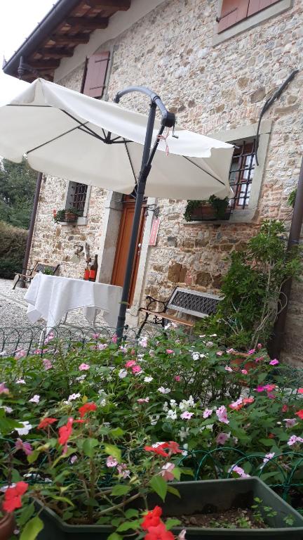 PradamanoAlloggio Agrituristico Conte Ottelio的大楼前的白色雨伞和鲜花