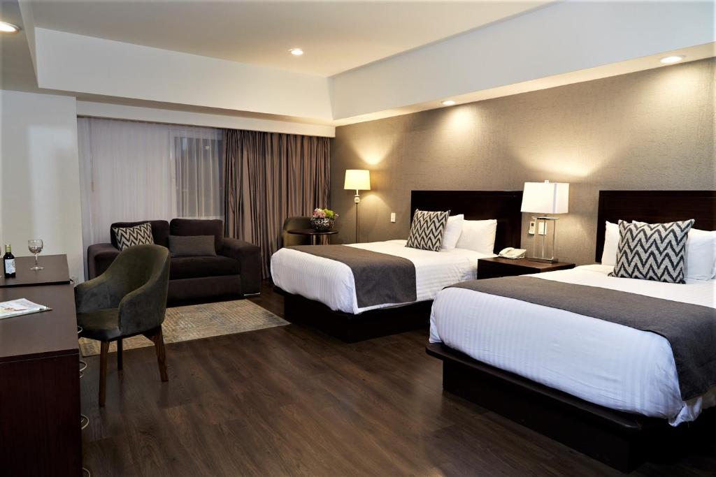 瓜达拉哈拉Ejecutivo Express Guadalajara Providencia - Av México的酒店客房,配有两张床和椅子