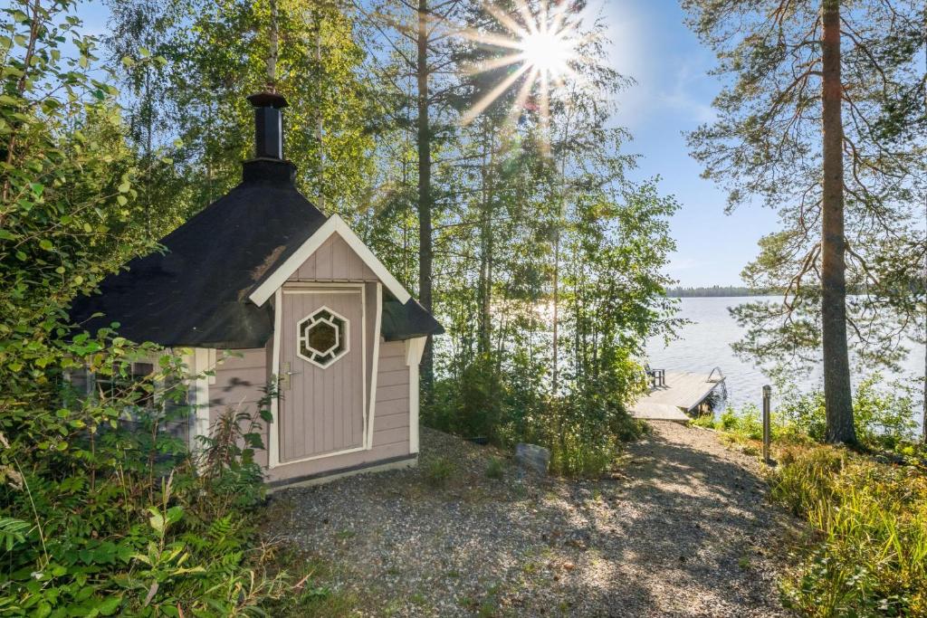 Kosula哈提图维特山林小屋的湖边的一座黑色屋顶的小房子