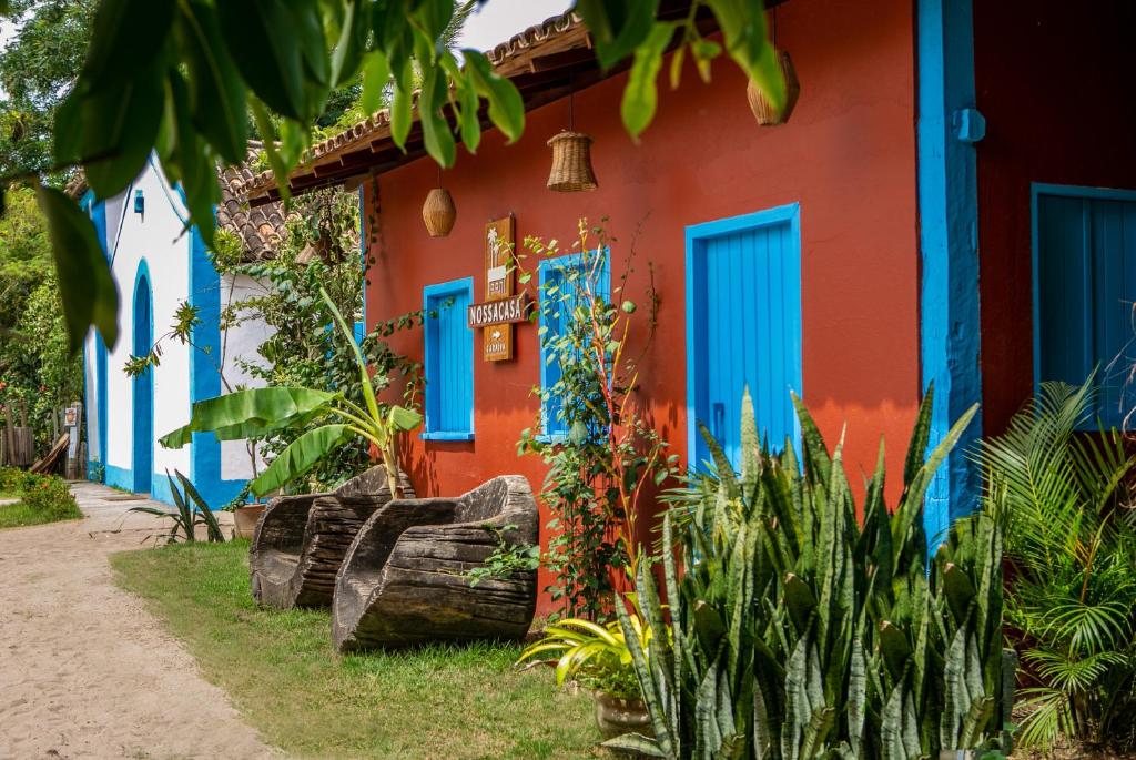 卡拉伊瓦Nossa Casa Caraíva - A melhor localização da Vila的色彩缤纷的房屋,拥有蓝色的门和植物