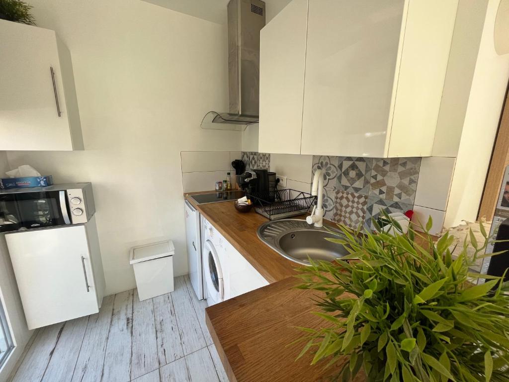 耶尔Studio proche de la plage de l'almanarre的厨房配有白色橱柜和水槽