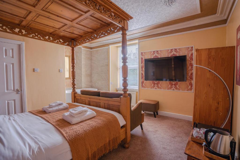 温德米尔小屋旅馆的一间卧室配有一张天蓬床和一台电视机