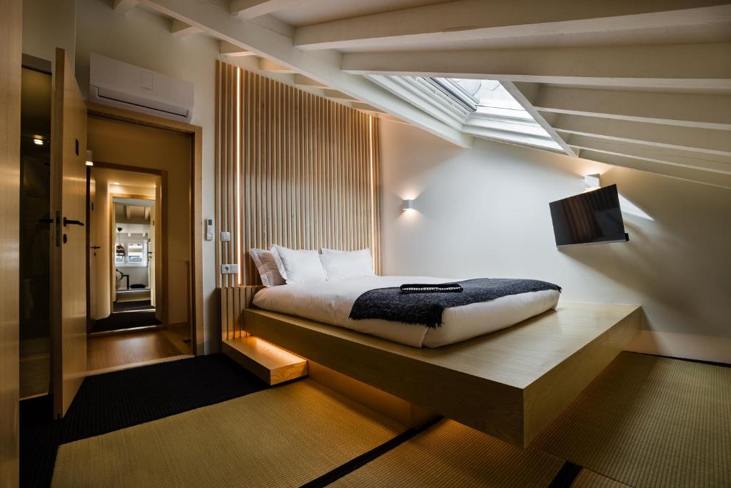 维塞乌Viseu Ryokan - Hospedaria Japonesa & SPA的一间卧室配有一张床和天窗
