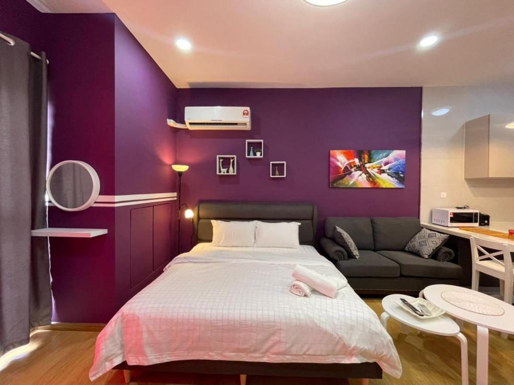 新山COUNTRY GARDEN@J Agape Homestay ~ STUDIO COMFORT的紫色卧室配有一张床和一张沙发