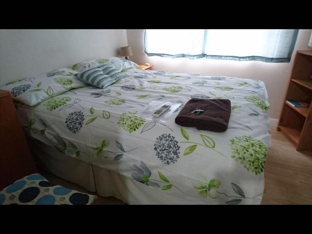 海斯Room in Guest room - Double with shared bathroom sleeps 1-2 located 5 minutes from Heathrow dsbyr的一张床上的白色毯子,上面有鲜花