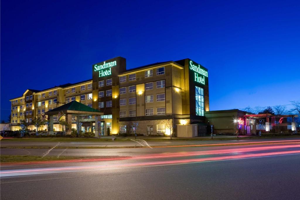 里士满桑德曼温哥华机场酒店的夜间有 ⁇ 虹灯的酒店大楼