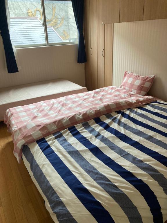 别府森のカフェ的一间卧室配有一张床,床上有条纹毯子