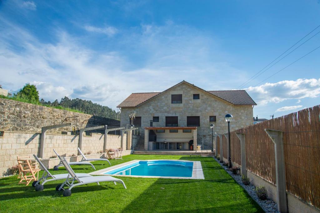 PortasWelcome Villa Briallos的一个带游泳池和房子的后院
