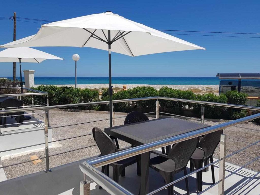 阿尔考斯布里Apartamentos Cap y Corp的海滩上配有桌椅和遮阳伞