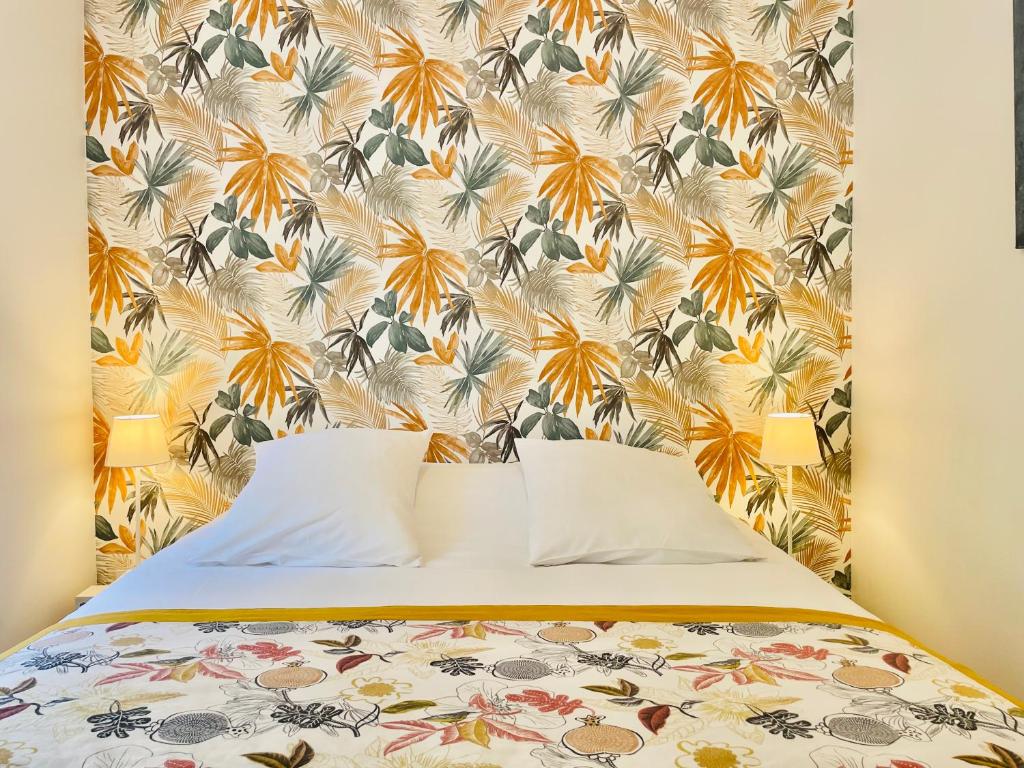 拉马卢莱班Hotel De Ma Tante的一间卧室配有一张带花卉壁纸的床