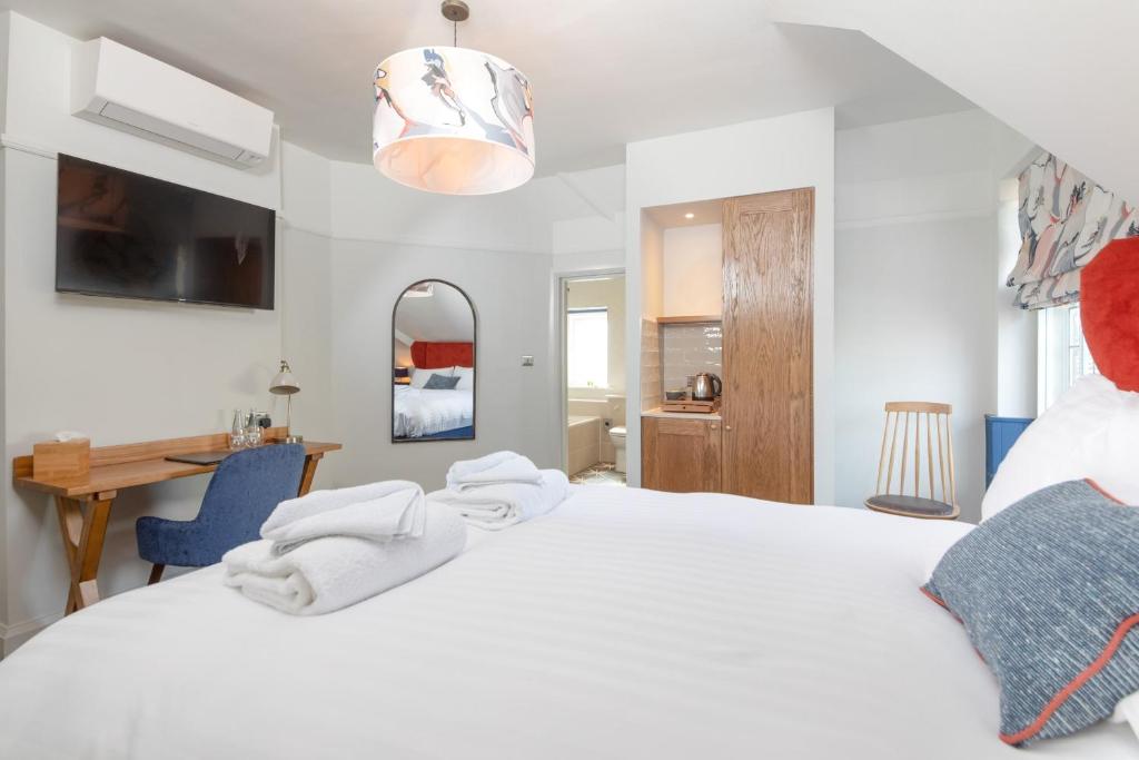 KnebworthThe Chequers Inn的卧室配有一张白色大床和一张书桌