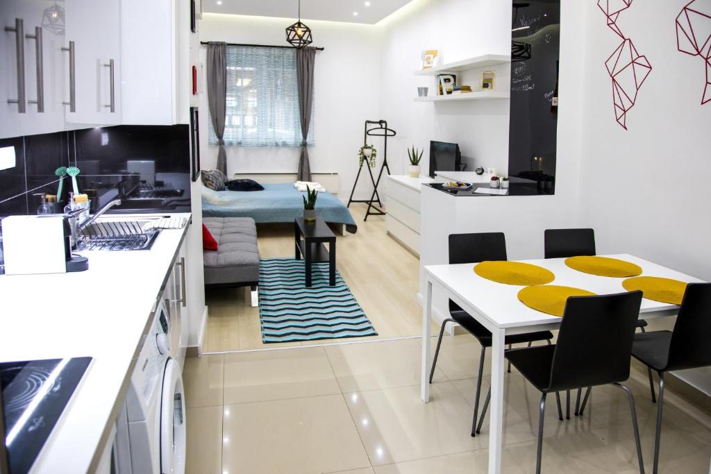 布达佩斯OAZU downtown flat的厨房以及带桌椅的起居室。