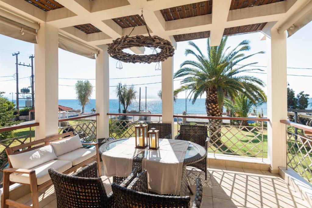 梅塔诺佛希斯#FLH - Vitamin Sea Beachfront Villa, Sithonia的一个带桌椅的庭院和大海