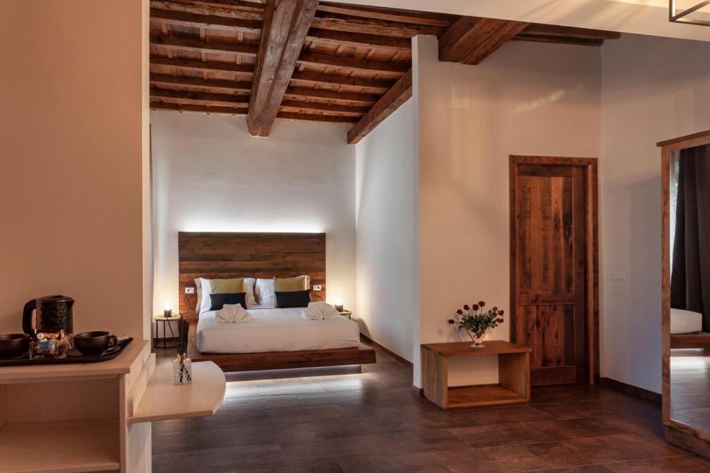 佛罗伦萨Oro Nero Florence的一间卧室配有一张大床和木制床头板