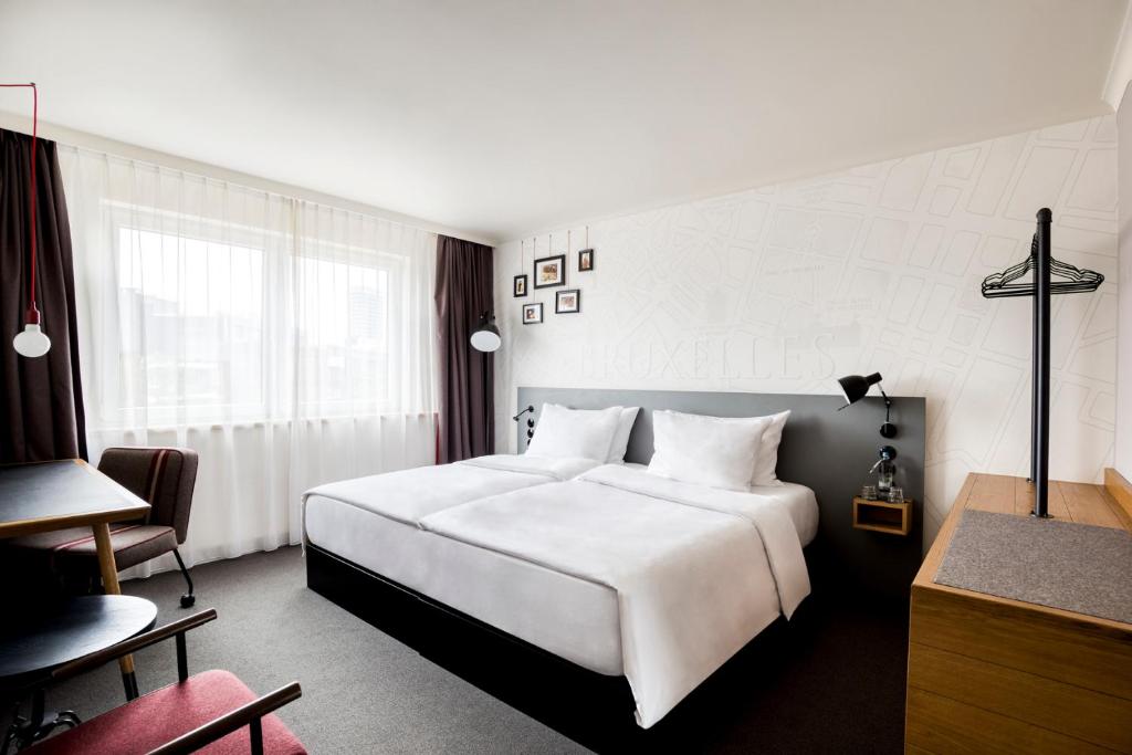 布鲁塞尔pentahotel Brussels City Centre的酒店客房设有一张白色大床和一张书桌